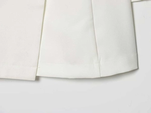 Detailed macro shot of white minimalist blazer set fabric with clean hemline stitching