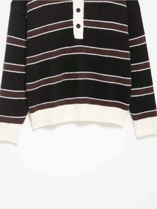 Gros plan du pull polo en maille rayé rétro avec poignets côtelés blancs et boutons