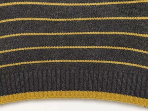 Detailed macro view of dark grey knit fabric with yellow stripes and ribbed hem texture