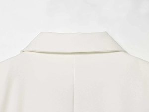 Detailed close-up of white minimalist blazer collar and high-quality woven fabric texture