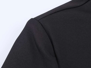 Detail of shoulder seam and twill fabric texture on a black tailored blazer