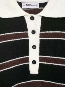 Gros plan détaillé du col polo en maille rayée avec quatre boutons noirs et texture douce