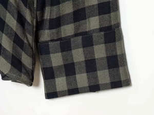 Detail of classic olive green and dark blue plaid shirt sleeve with fine stitching