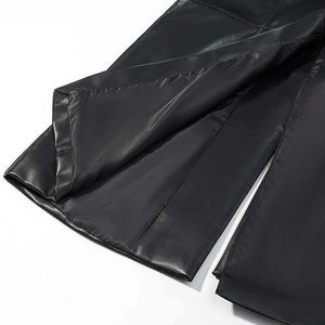 Gros plan sur l'ourlet fendu et les coutures d'un manteau en cuir noir pour femme