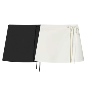 Detail of a minimalist wrap mini skirt featuring a black and white color block design