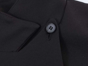 Detail of black stand-up collar blazer with diagonal twill fabric and resin button closure