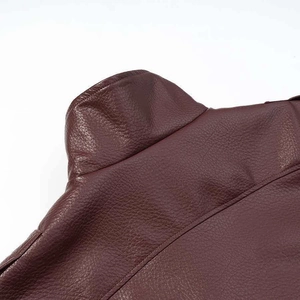 Detail of burgundy faux leather bomber jacket showing grainy texture and stitching
