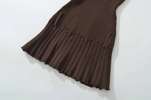 Detailed view of dark brown knitted pleated dress hem with ruffled edges and belt loops