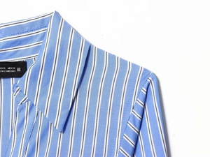 Detailed view of striped shirt dress collar with size label and fabric texture