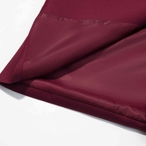 Détail de l'ourlet du blazer bordeaux foncé montrant le tissu et la doublure soyeuse