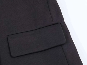 Close-up of a black blazer flap pocket showing high-quality twill woven fabric detail