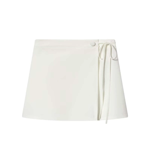 Detail view of the white wrap mini skirt with waist ribbon tie and button closure