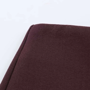 Dettaglio ravvicinato della trama del tessuto viola scuro e cuciture uniformi dei pantaloncini