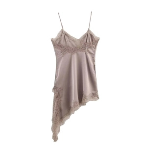 Détail d'une robe en satin rose poudré avec dentelle délicate et ourlet asymétrique