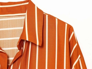 Detail of the orange striped shirt collar with high-quality stitching on lightweight fabric