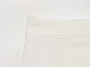 Detailed close-up of white skirt waistline showing clean stitching and matte cotton fabric