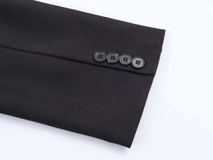 Detail of four black buttons on the sleeve cuff of a commuter suit jacket
