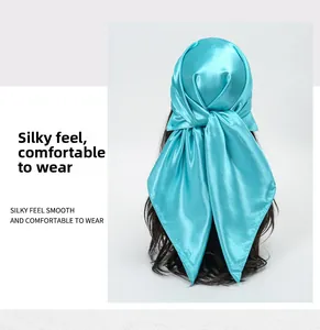 Detail view of turquoise satin scarf showing silky texture and smooth glossy finish on head