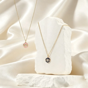Elegant gold Evil Eye pendant necklace with cubic zirconia and enamel on silk background