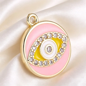 Macro shot of gold-plated pink enamel evil eye charm with micro-set cubic zirconia stones