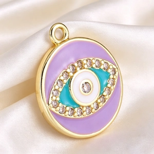 Detailed macro view of gold-plated evil eye charm with purple enamel and cubic zirconia