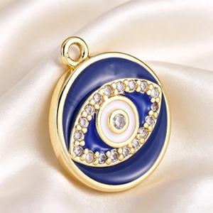 Macro shot of gold-plated evil eye pendant with blue enamel and sparkling cubic zirconia