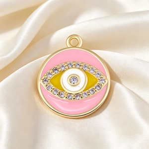 Detailed view of pink enamel evil eye charm with gold plating and cubic zirconia inlay