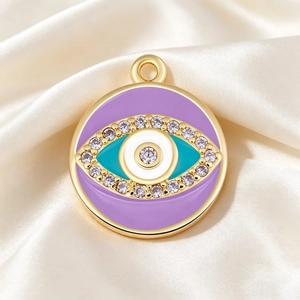 Close-up of purple evil eye pendant with cubic zirconia and gold plating on silk background