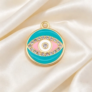 Macro shot of colorful enamel evil eye pendant with cubic zirconia on silk background