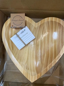 Detail view of heart-shaped wooden prayer bowl with crosses and prayer cards