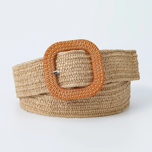 Close-up of woven straw belt with a large orange square resin buckle and metal pin