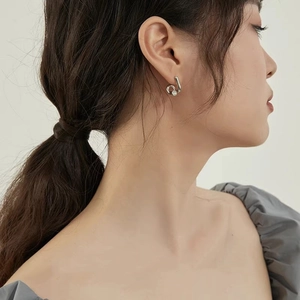 Elegant silver curved zircon earrings on a model for a modern minimalist jewelry look