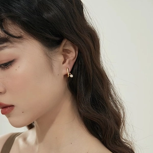 Minimalist gold curved C-shape stud earring with cubic zirconia on female model