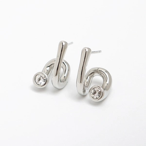 Detailed close-up of silver twist earrings with a sparkling round zircon stone