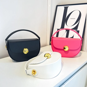 Three minimalist semi-round leather handbags in black, rose red, and white with gold clasps