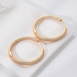 Close-up detail of gold-plated hoop earrings with sparkling micro-pave zirconia stones