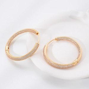 Close-up of gold-plated hoop earrings with sparkling cubic zirconia micro-pave setting.