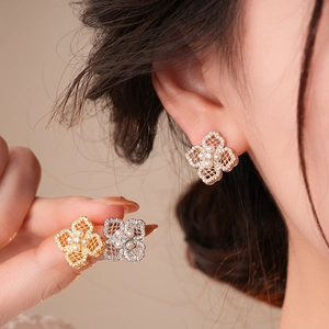 Detail of 18K gold plated flower stud earrings with pearls and crystals on ear