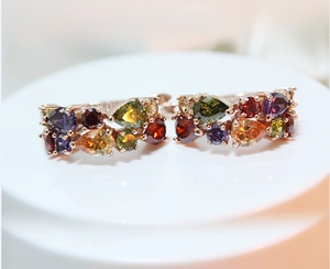 Detailaufnahme der Roségold-Huggie-Ohrringe mit bunten Zirkonia in Tropfenform