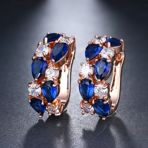Detail von Roségold-Ohrringen mit birnenförmigen blauen Kristallen und Zirkonia