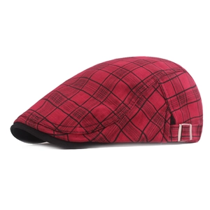 Detail view of red plaid beret with black brim and adjustable silver metal side buckle