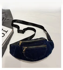 Detail view of the deep blue denim waist bag showing texture and double metal zippers