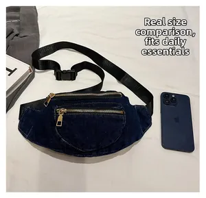 Detail view of denim waist bag showing zip pockets with phone and book for size scale