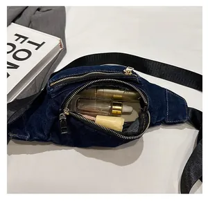 Detail of denim chest bag interior with metal zipper showing spacious storage capacity