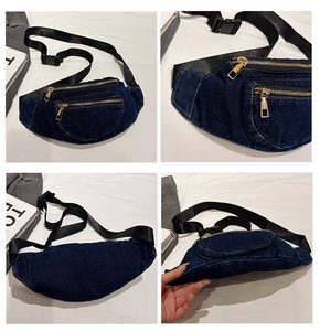 Macro details of dark wash denim fanny pack with gold metal zippers and stitching