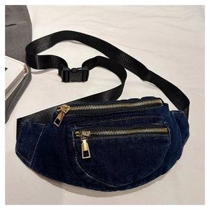 Detailed macro view of dark denim waist bag with gold zippers and adjustable nylon strap