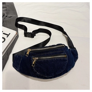 Detail of dark blue denim fanny pack with gold metal zippers and nylon adjustable strap