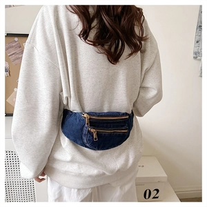 Rear view of a model wearing a deep blue denim fanny pack with golden zippers