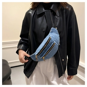 Detail view of denim crossbody bag with dual gold zippers and adjustable strap