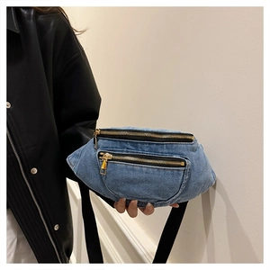 Detail showing blue denim waist bag with gold zippers and black nylon shoulder strap